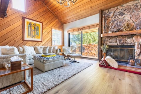 Warm and inviting living room with vaulted wood ceilings, a stone fireplace, and plush sectional seating, perfect for cozy nights after a day on the slopes.