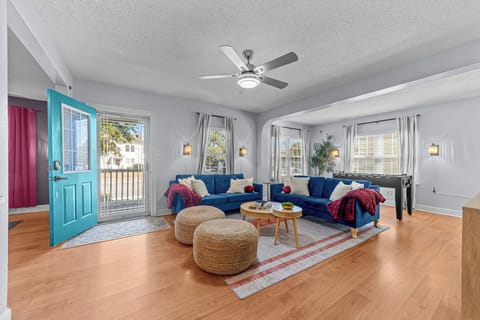 Living room with plush couch, ceiling fan, and foosball