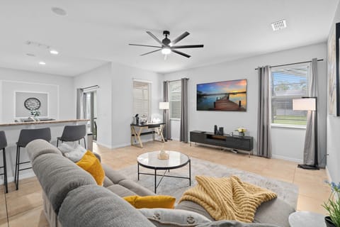 Modern living room with seating for plenty, an 85 inch tv, workspace