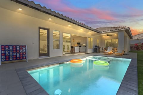 Unwind by the glowing pool at sunset, w/ covered patio seating & soft evening lights