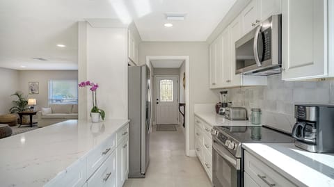 Kitchen stocked with pots, pans, plates and utensils and plenty of counter space
