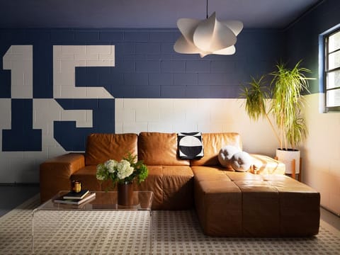 Stylish living room with leather sectional sofa and bold blue graphic mural