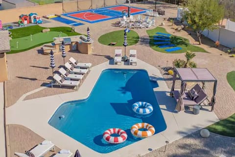 Expansive private backyard with heated pool, pickleball court, volleyball, basketball, mini golf, and a cozy firepit — perfect for large groups and family fun in Scottsdale.