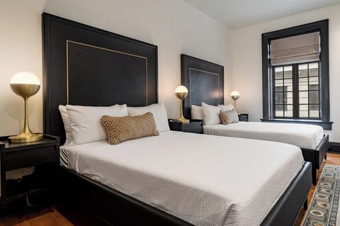 Bedroom 1 - Double queen beds featuring a built-in wardrobe and flat-screen TV.