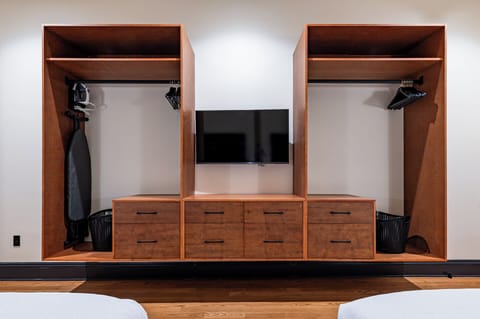 Bedroom 1 - Large closet space equipped with hangers, laundry hampers, and iron with ironing board.
