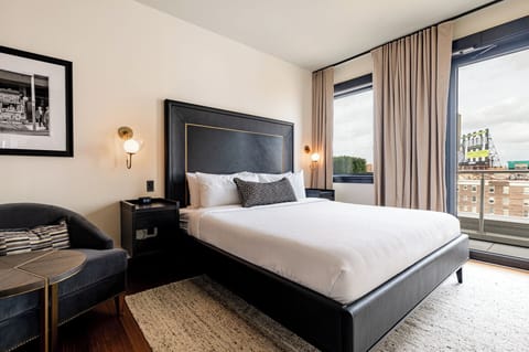 Bedroom 1 - King bed featuring a built-in wardrobe, flat-screen TV, and direct access to private patio with downtown views.