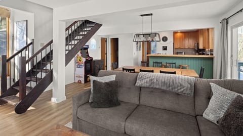 - Living area with arcade game corner and direct kitchen access   - Comfortable sofa seating perfect for family and friends   - Open floor plan connects entertainment and dining spaces