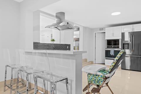 Stylish Kitchen: Enjoy modern design with chic bar stools, stainless steel appliances, and bright vibes!