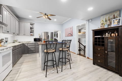  The kitchen is fully stocked with a large island and bar stools.