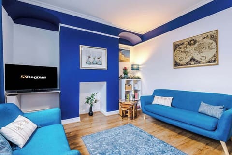 This city centre living room features a smart TV, comfortable sofas, and a selection of games. The space is modern and inviting, perfect for both relaxation and entertainment.