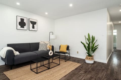 The living room’s plush seating beckons you to sink in and relax, surrounded by light and airy decor.