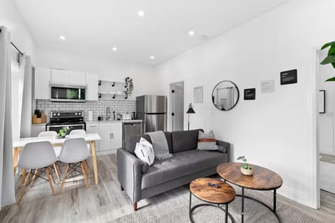 Spacious open-concept living and dining area featuring a vibrant sofa, modern furnishings, and a stylish entertainment setup—ideal for gatherings and relaxation.