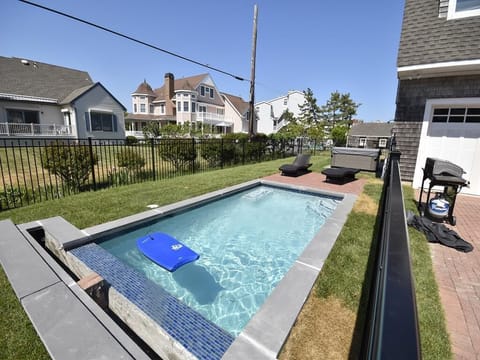 Refreshing shared pool in a private fenced-in yard – ideal for a quick swim after the beach.