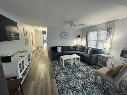 Cozy living room with comfortable seating, a flat-screen TV, and plenty of natural light, perfect for unwinding after a day at the beach.