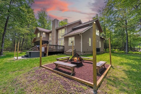 Toast marshmallows fireside as the sky turns violet behind your cabin’s glowing hot tub deck.