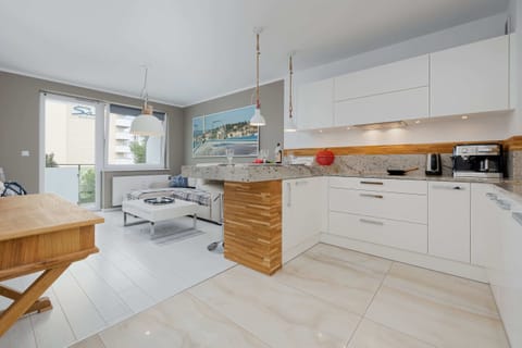  A sleek kitchen with white cabinets, wooden countertops, and bright lighting, perfect for home cooking enthusiasts.