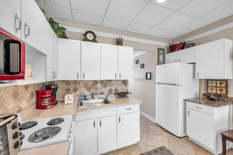 Bright, open kitchen w/ white cabinetry and plenty of space for everyday meals.