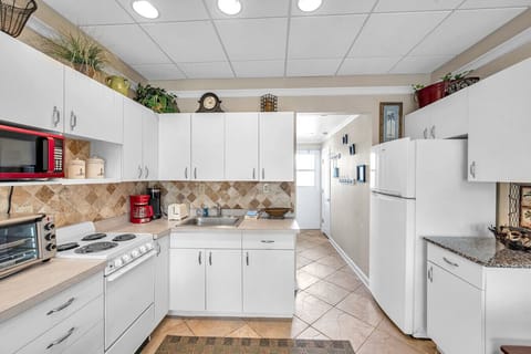 Bright, fully equipped kitchen w/ ample counter space for easy home cooking.