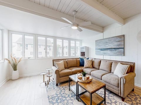 Spacious and sunlit living area with large windows, creating a bright and inviting space to gather and relax with family and friends.