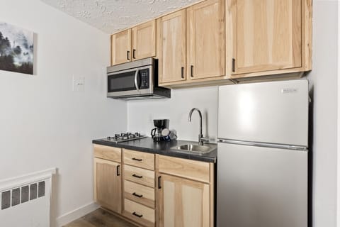 Efficient kitchen area offering stainless appliances and wood-style cabinetry.