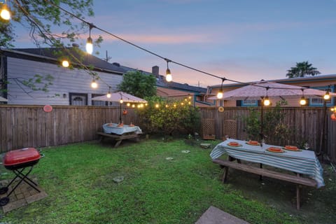 Enjoy a meal or drink in your NOLA backyard oasis with a charcoal grill, picnic benches, umbrellas, 