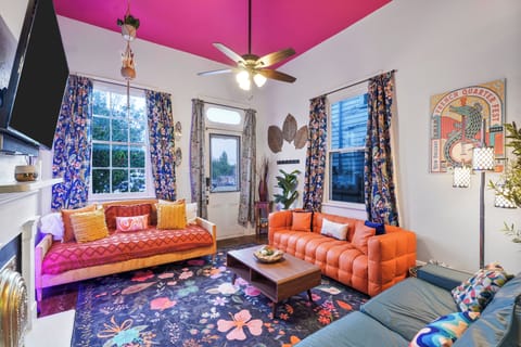 The colorful, eclectic living room reflects the vibrant nightlife of St. Claude Ave, just outside.