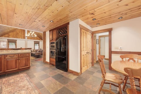 Your spacious kitchen features warm wood cabinets, modern appliances, and rustic charm with exposed beam ceilings for memorable meal preparation.