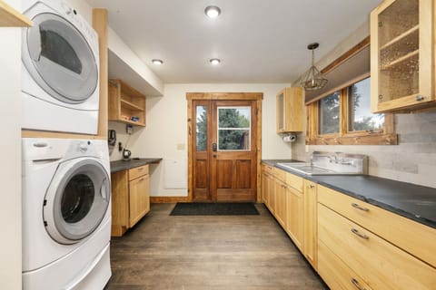 Your spacious kitchen flows seamlessly into the laundry area, featuring warm wood cabinets and modern appliances for comfortable meal prep and easy cleanup.