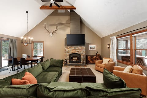 Gather in the vaulted living room w/ plush seating, warm fireplace & cozy cabin charm