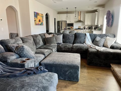 Oversized sectional w/ TV mounted on floor to ceiling stone fireplace 