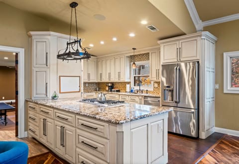 A gourmet kitchen designed for culinary adventures, featuring sleek granite countertops, stainless steel appliances, and plenty of space to gather and create meals together.