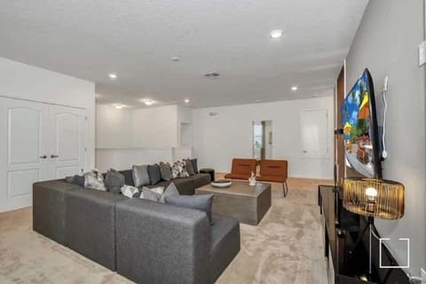 Relax in this spacious living room with a comfy sectional, chic decor, and a large TV for entertainment.