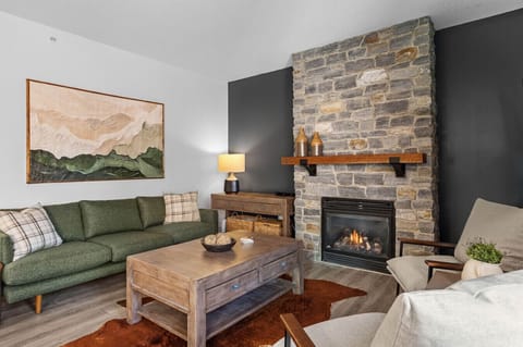 Modern and spacious living room. Beautiful stone fireplace to curl up after a day of adventures.