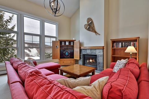 Settle into the sectional beside the fireplace while tall windows frame the mountain scenery.