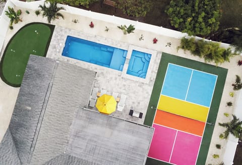 Aerial of putting green, swimming pool and spa, and pickleball court