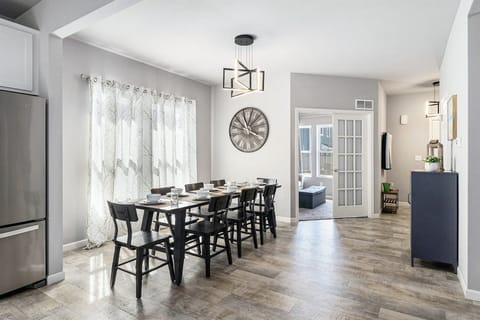 The dining room has space for 8 people to sit, with 3 more seats at the kitchen island
