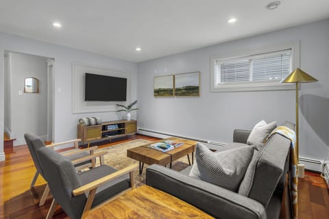 Modern living room with stylish decor, featuring a comfortable gray sofa, two matching armchairs, and a wooden coffee table. Perfect for relaxing or entertaining guests.
