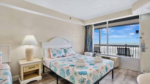 Cozy beachside room with ocean views and balcony seating.