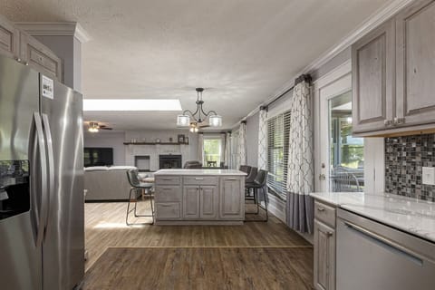 Modern kitchen with stainless steel appliances and wooden floors.