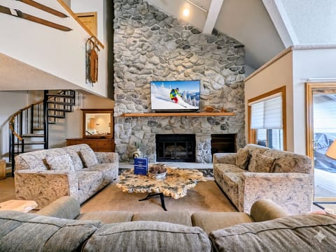 Cozy up by the crackling fireplace in your spacious living area, where stone walls and vaulted ceilings create mountain lodge charm.