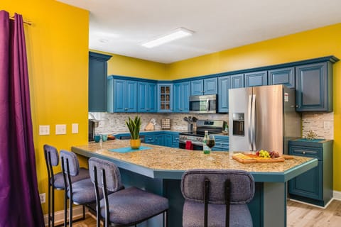 Cook with ease in a fully stocked kitchen featuring bold blue cabinets and granite counters.