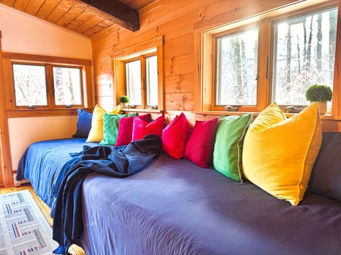 A cheerful common space with two colorful twin beds, perfect for relaxing and unwinding.