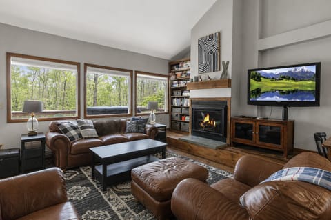 Floor-to-ceiling forest views, fireplace warmth, and cozy four-season mountain retreat vibes