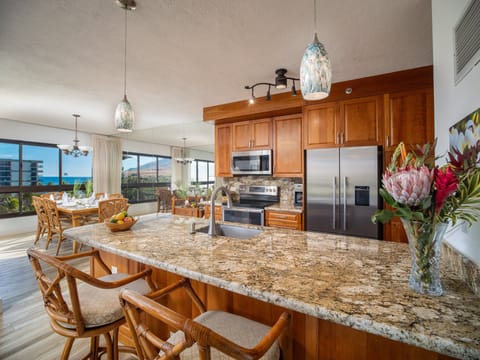 Enjoy a fully equipped gourmet kitchen with granite countertops and ocean views, ideal for cooking and dining in paradise.