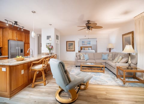 Relax in the elegant living room featuring tropical decor, plush seating, and an open layout perfect for family gatherings.