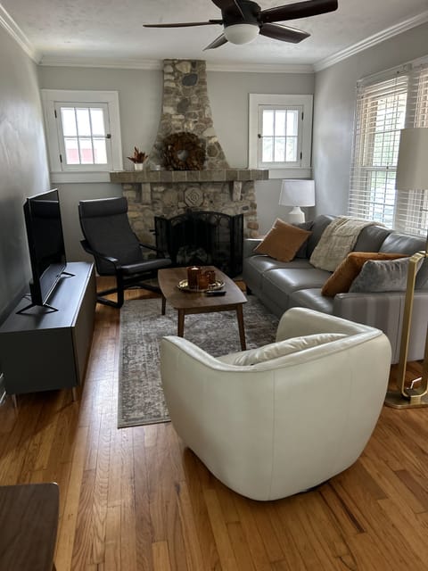 Living room features a stone fireplace, smart, and stylish furnishings.