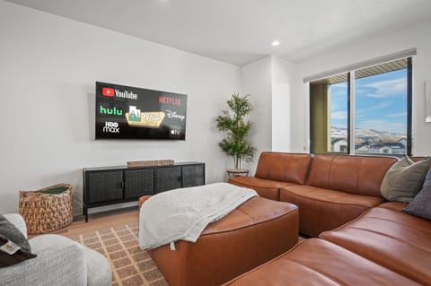 Experience the cozy living room, outfitted with plush seating, an expansive smart TV, and breathtaking mountain vistas.