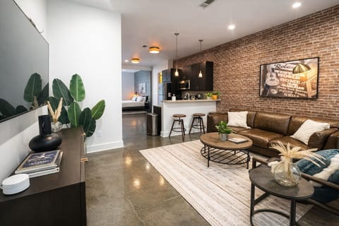 Living room with Smart TV opening up to the kitchen and bedroom areas