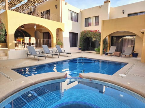 The outdoor area boasts a sparkling pool, a relaxing jacuzzi, and a spacious patio, perfect for lounging, entertaining, or enjoying the beautiful Cabo weather.