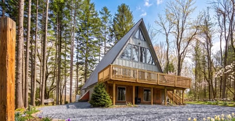 Modern A-frame surrounded by towering Pocono pine trees.